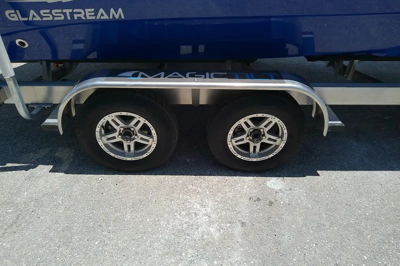 Slide: The Image of 2025 Glasstream 240 CCX boat on Magic Tilt trailer, featuring dual wheels. - 42