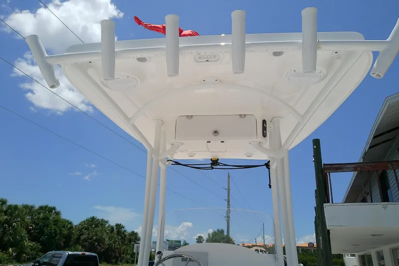 Slide: The Image of 2025 Glasstream 240 CCX boat's T-top with rod holders against a clear blue sky. - 7