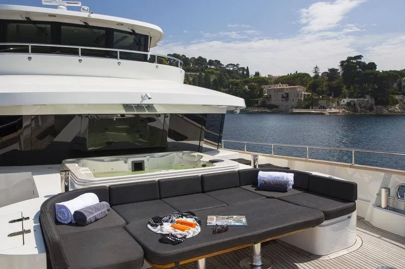 Slide: The Image of Luxurious 2014 Fifth Ocean Yachts Explorer with deck seating and jacuzzi, overlooking serene coastal scenery. - 89