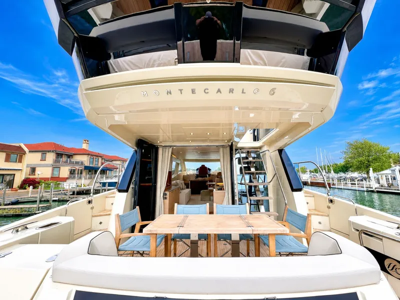 Slide: The Image of 2019 Monte Carlo MC6 yacht docked with outdoor seating area. - 13