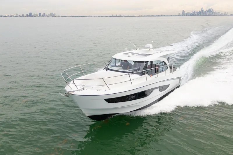 Slide: The Image of 2023 Beneteau Antares 11 cruising on open water near city skyline. - 15