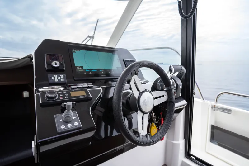 Slide: The Image of Helm of 2023 Beneteau Antares 11 with navigation controls and steering wheel. - 25