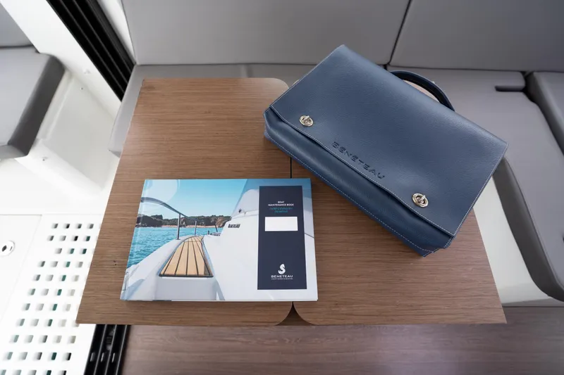 Slide: The Image of Beneteau Antares 11, 2023 model, brochure and blue leather case on wooden table. - 36