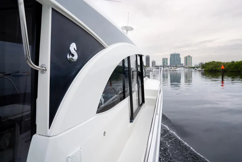 Slide: The Image of 2023 Beneteau Antares 11 cruising near city skyline on calm waters. - 38