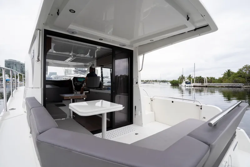 Slide: The Image of 2023 Beneteau Antares 11 boat interior with seating and table, docked by calm waters. - 40