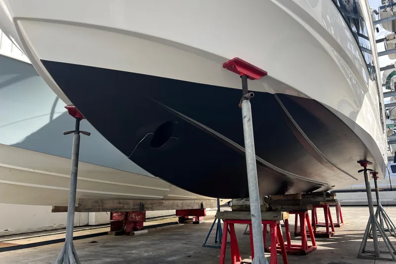 Slide: The Image of 2023 Beneteau Antares 11 boat hull on stands in a shipyard. - 50