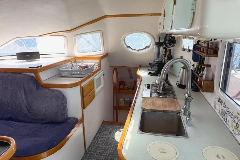 Slide: The Image of Interior of a 2004 Outremer Standard yacht featuring a cozy kitchen and seating area. - 11