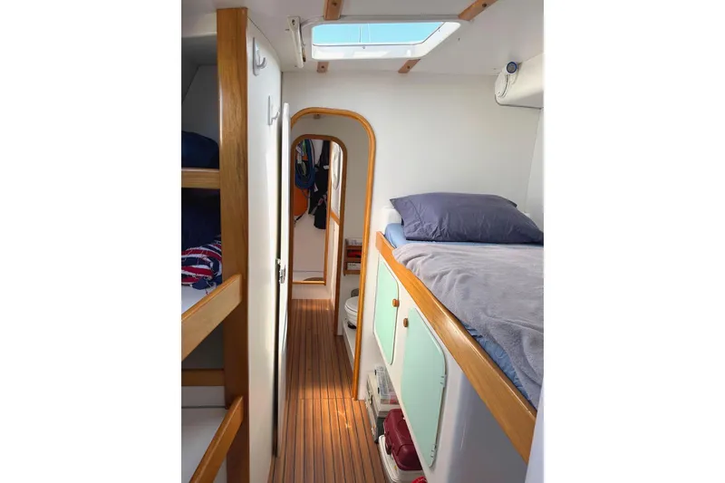 Slide: The Image of Interior of 2004 Outremer Standard yacht with cozy sleeping quarters and wooden accents. - 15
