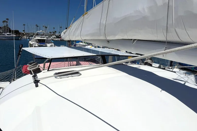 Slide: The Image of 2004 Outremer Standard catamaran docked in a marina, featuring sails and deck equipment. - 6