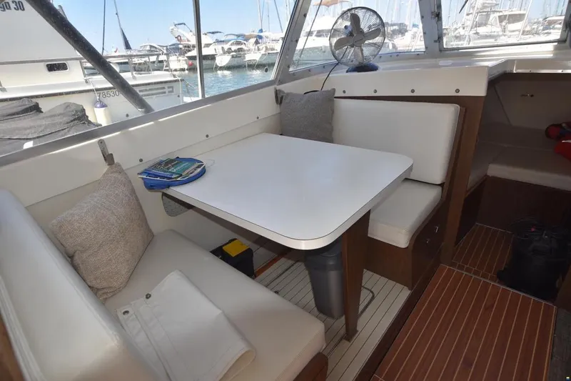 Slide: The Image of Cozy dining area inside a 2004 Outremer Standard yacht, featuring cushioned seating and a table. - 9