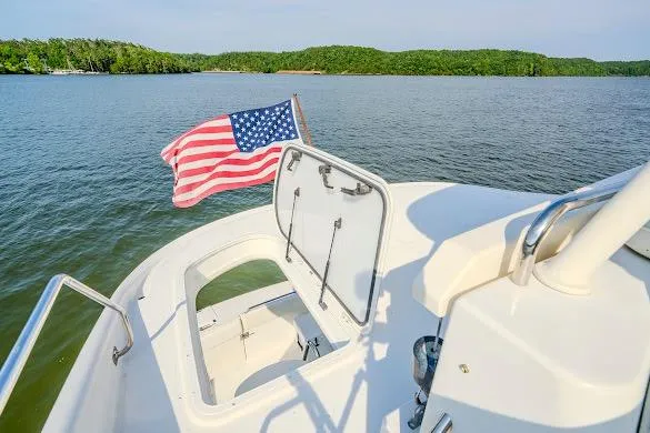 Slide: The Image of 2003 Carver 570 Voyager Pilothouse yacht with American flag on serene lake. - 31