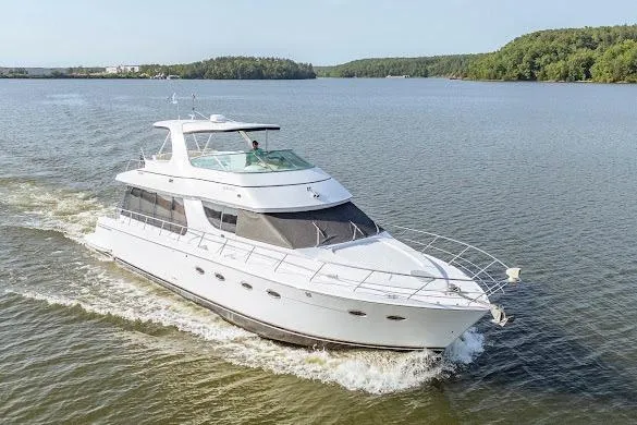 Slide: The Image of 2003 Carver 570 Voyager Pilothouse yacht cruising on a serene lake. - 7