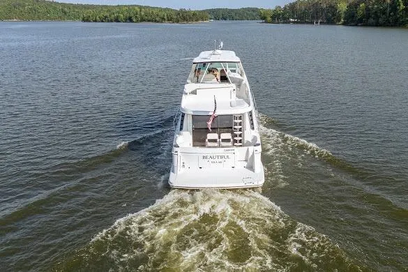 Slide: The Image of 2003 Carver 570 Voyager Pilothouse cruising on a serene lake. - 9