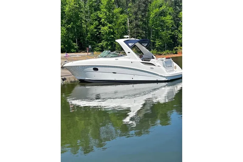 The Image of 2010 Sea Ray Sundancer 310 yacht on calm water, surrounded by lush greenery. - 1