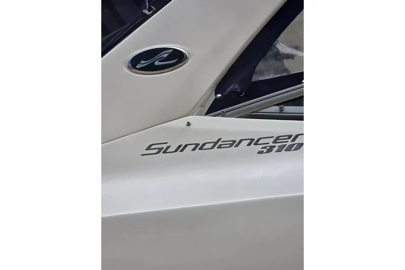 Slide: The Image of 2010 Sea Ray Sundancer 310 boat logo and model name on hull. - 2