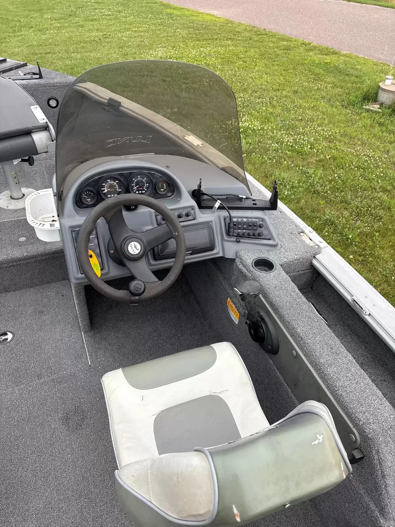 Slide: The Image of The image shows the cockpit of a 2005 Lund 1700 EXP/SS boat with steering and instruments. - 6