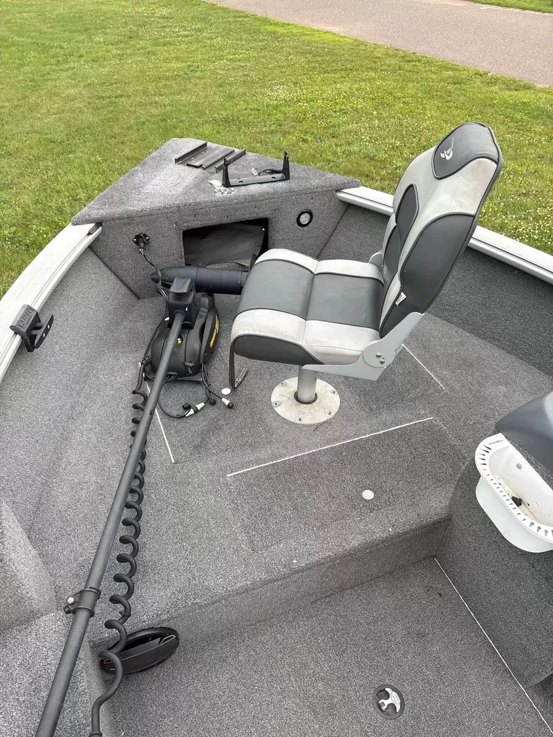 Slide: The Image of A gray boat with a cushioned seat and a trolling motor on a green lawn. - 3
