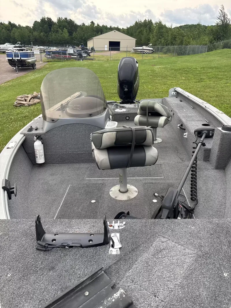 Slide: The Image of The image shows a 2005 Lund 1700 EXP/SS boat with two seats and an outboard motor. - 4