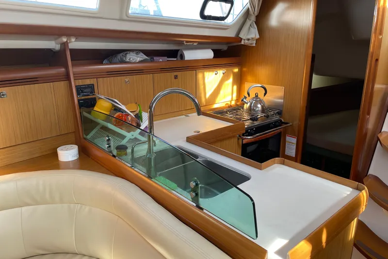Slide: The Image of Interior of 2008 Jeanneau Sun Odyssey 39i yacht, featuring a modern kitchen galley. - 10