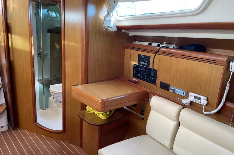 Slide: The Image of Interior of 2008 Jeanneau Sun Odyssey 39i yacht, featuring navigation panel and compact bathroom. - 11