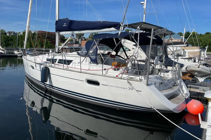 Slide: The Image of 2008 Jeanneau Sun Odyssey 39i sailboat docked in a marina under clear blue skies. - 2