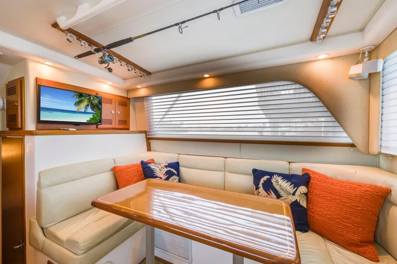 Slide: The Image of Luxurious 2005 Cabo 35 Flybridge interior with plush seating, vibrant cushions, and a mounted TV. - 19