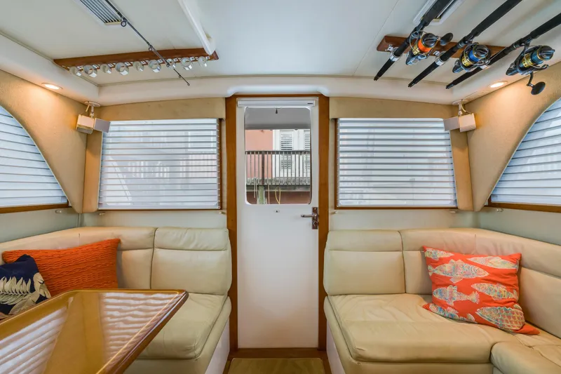Slide: The Image of Interior of 2005 Cabo 35 Flybridge with beige seating and fishing rods. - 20