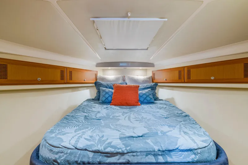 Slide: The Image of Luxurious cabin interior of 2005 Cabo 35 Flybridge with cozy bedding and wooden storage. - 21