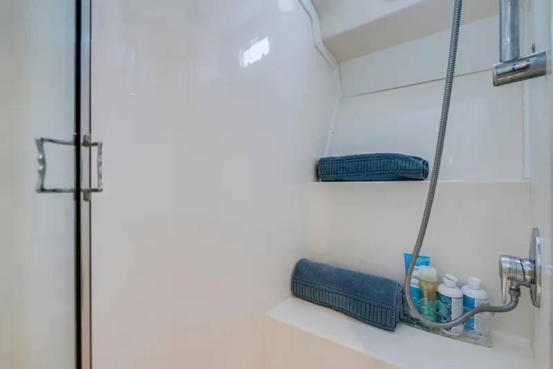 Slide: The Image of 2005 Cabo 35 Flybridge bathroom with towels and toiletries on shelves. - 27