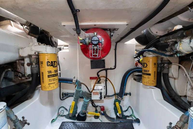 Slide: The Image of Engine room of 2005 Cabo 35 Flybridge with CAT oil filters and fire extinguisher. - 28