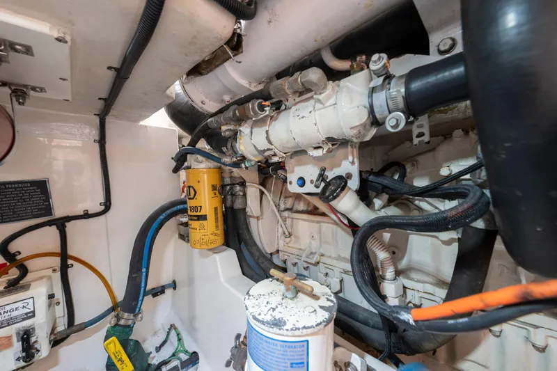 Slide: The Image of Engine room of a 2005 Cabo 35 Flybridge boat, showcasing mechanical components and wiring. - 30