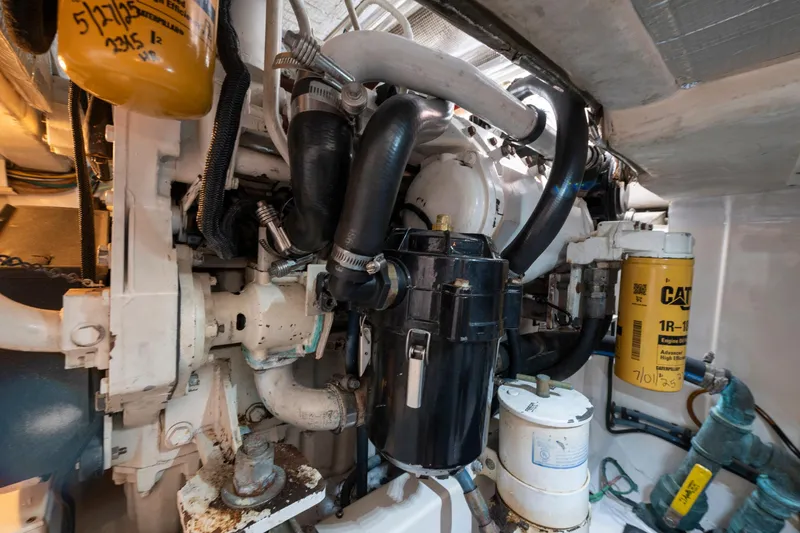 Slide: The Image of Engine room of a 2005 Cabo 35 Flybridge boat, showcasing mechanical components and filters. - 31