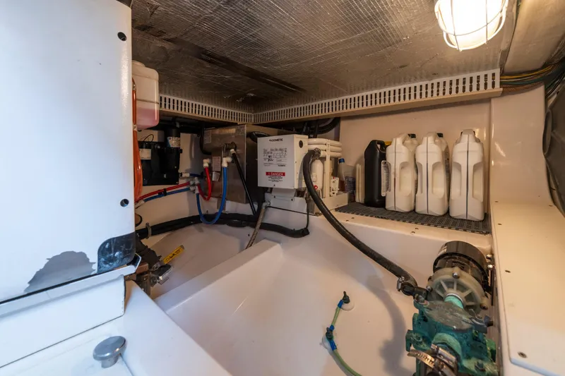 Slide: The Image of Engine room of 2005 Cabo 35 Flybridge with equipment and storage containers. - 32