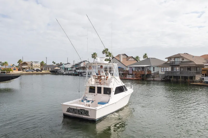 Slide: The Image of 2005 Cabo 35 Flybridge boat cruising near waterfront homes. - 4