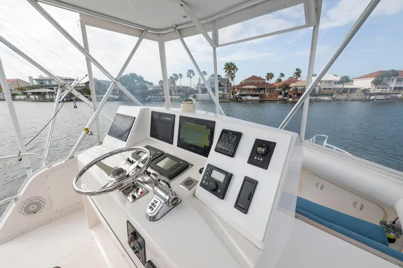 Slide: The Image of Helm of 2005 Cabo 35 Flybridge boat with navigation instruments and waterfront view. - 6
