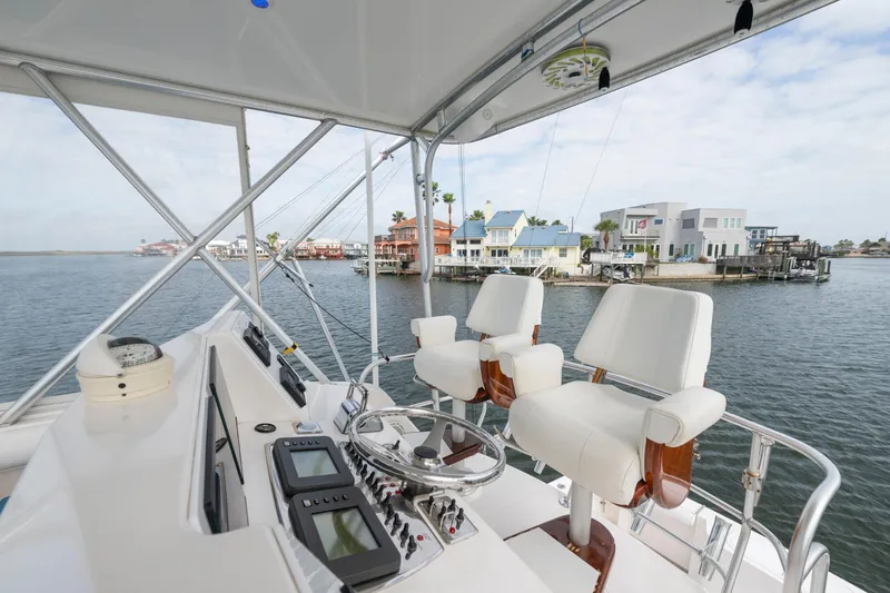 Slide: The Image of Flybridge view of 2005 Cabo 35 yacht with waterfront homes in the background. - 7