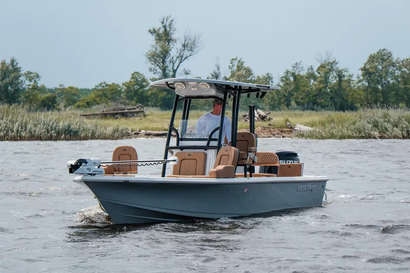 Slide: The Image of 2022 Sea Pro 228 Bay boat cruising on a scenic waterway with lush greenery. - 10