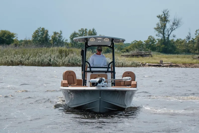 Slide: The Image of 2022 Sea Pro 228 Bay boat cruising on a scenic waterway with lush greenery. - 11