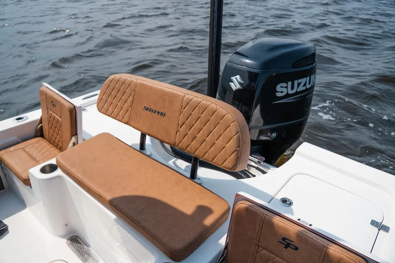 Slide: The Image of 2022 Sea Pro 228 Bay boat with Suzuki engine, featuring tan quilted seating. - 16