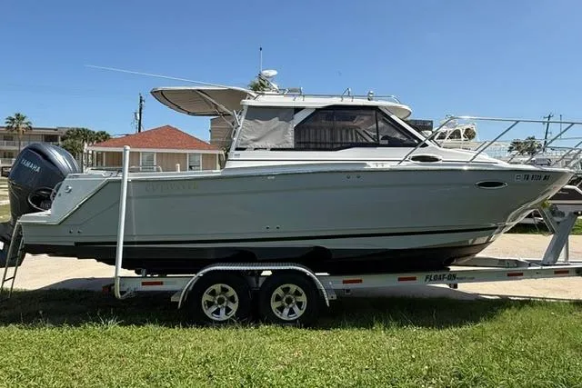 Slide: The Image of 2025 Cutwater C-248 Coupe boat on trailer, side view, outdoors. - 2