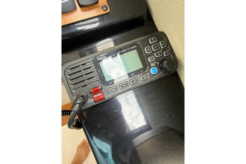 Slide: The Image of VHF radio on 2025 Cutwater C-248 Coupe dashboard, featuring distress button and display. - 21