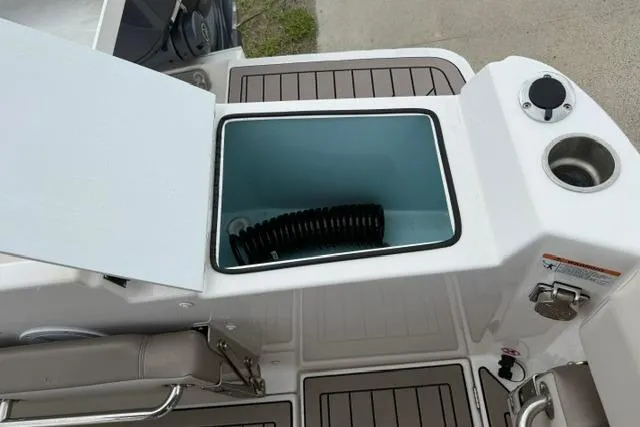 Slide: The Image of 2025 Cutwater C-248 Coupe boat deck with open storage compartment and cup holder. - 26
