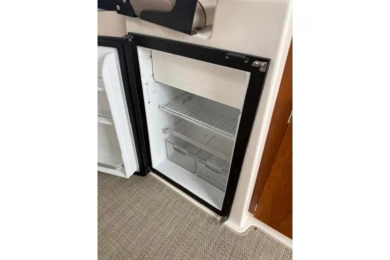Slide: The Image of Open refrigerator inside 2025 Cutwater C-248 Coupe boat, showcasing interior storage space. - 28