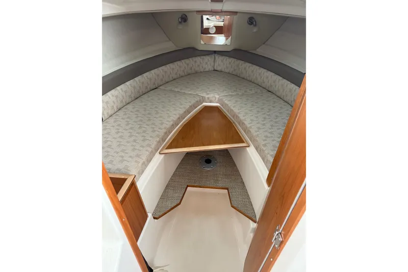 Slide: The Image of 2025 Cutwater C-248 Coupe cabin interior with cozy seating and wooden accents. - 34
