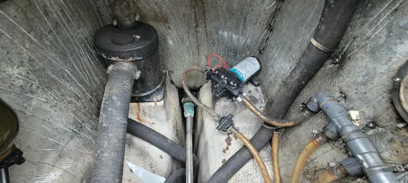 Slide: The Image of Engine compartment of a 1987 Island Packet 31 with hoses and pump. - 33