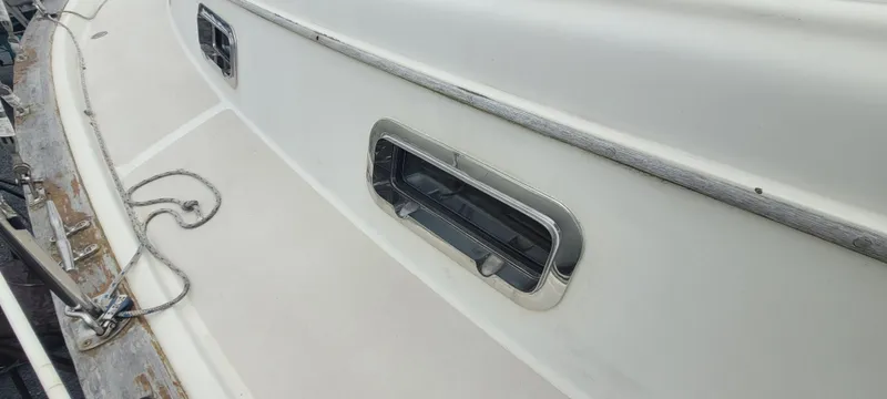 Slide: The Image of Close-up of a 1987 Island Packet 31 boat deck with windows. - 37