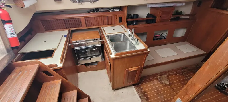 Slide: The Image of Interior of a 1987 Island Packet 31 sailboat with kitchen and wood paneling. - 9