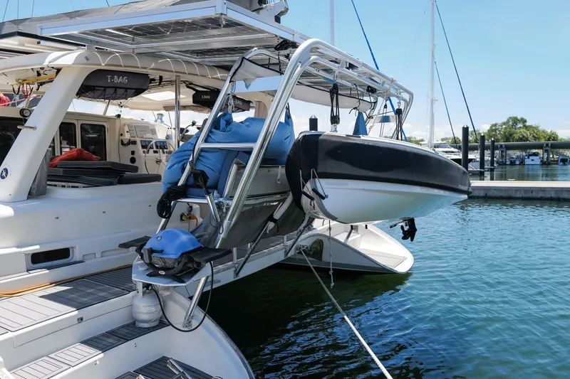Slide: The Image of 2006 Leopard 43 catamaran with dinghy, docked at marina, showcasing sleek design and spacious deck. - 22