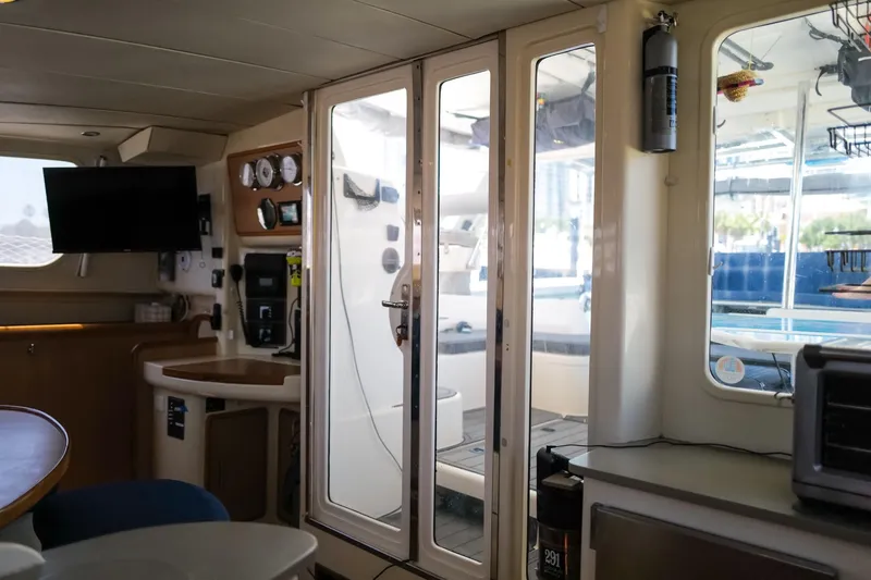 Slide: The Image of Interior of a 2006 Leopard 43 catamaran featuring a modern navigation station and cozy seating area. - 24