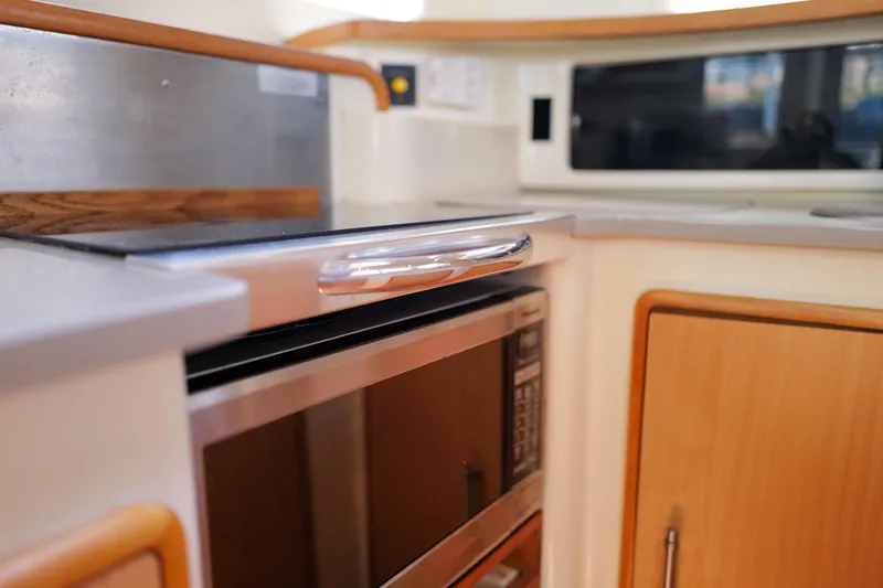 Slide: The Image of Modern kitchen area in a 2006 Leopard 43 yacht, featuring a microwave and sleek cabinetry. - 35